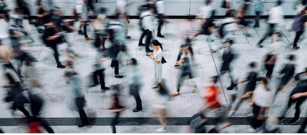 Busy professional scanning a smart device for important information amidst a crowded walkway